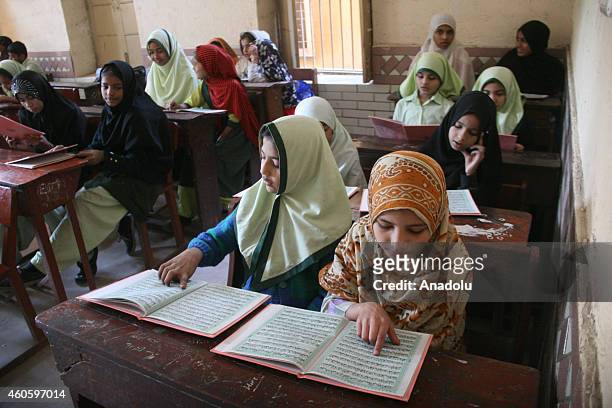 Pakistani school children read Qur'an for victims, who were killed in a Taliban attack at the army-run school in Peshawar, during a memorial ceremony...