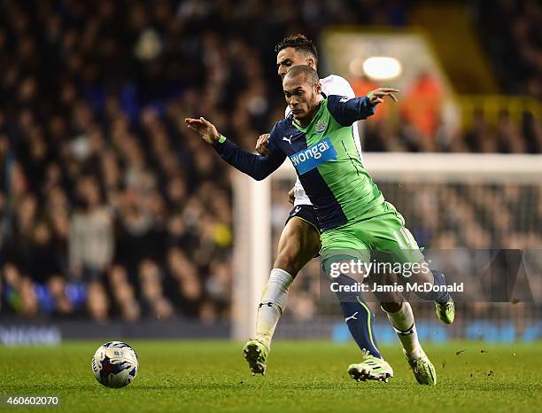 Yoan Gouffran of Newcastle United is challenged by Nacer Chadli of Tottenham Hotspur during the Capital One Cup Quarter-Final match between Tottenham...