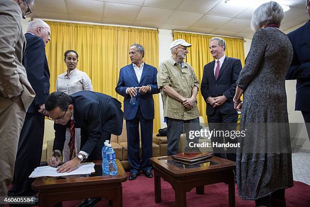 Alan Gross chats with Rep. Chris Van Hollen, D-Md. As the final paperwork gets signed by a Cuban official on his release December 17, 2014 at an...