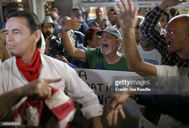 Group of people tell Peter Bell who supports the new policy laid out by President Barack Obama to leave as people gathered outside the Little Havana...