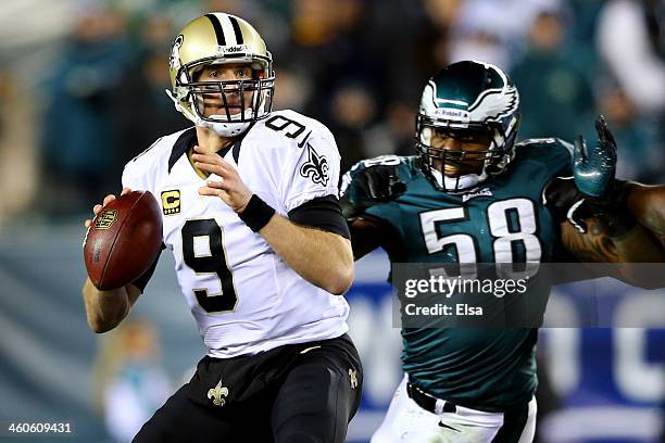 Drew Brees of the New Orleans Saints looks to throw a pass in the first quarter against Trent Cole of the Philadelphia Eagles during their NFC Wild...