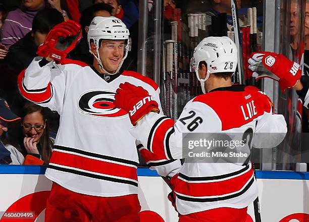 Brett Sutter of the Carolina Hurricanes is congratulated on his second period goal by teammate John-Michael Liles during the game against the New...