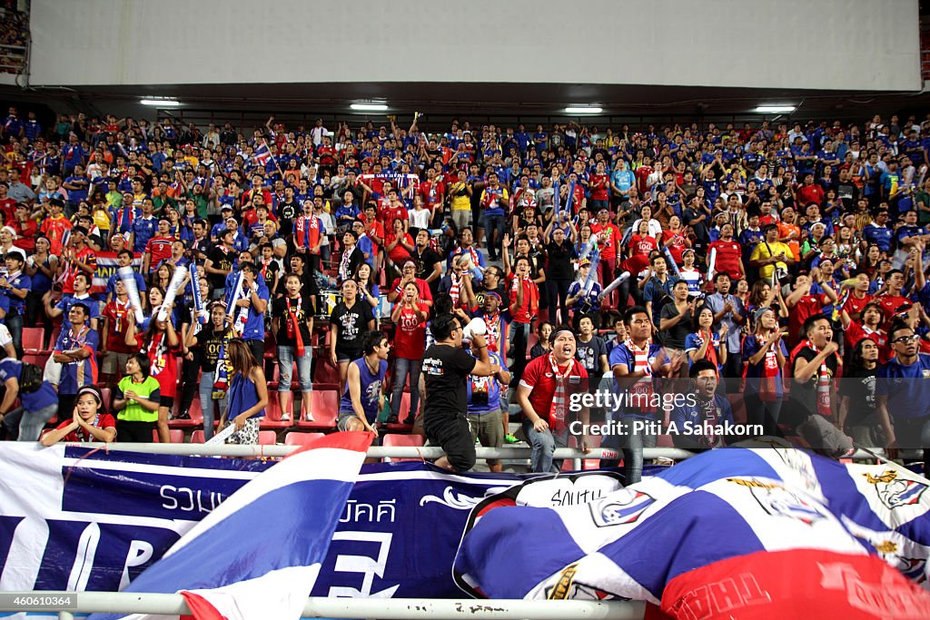 Thai football fans cheer during the first leg match of the...