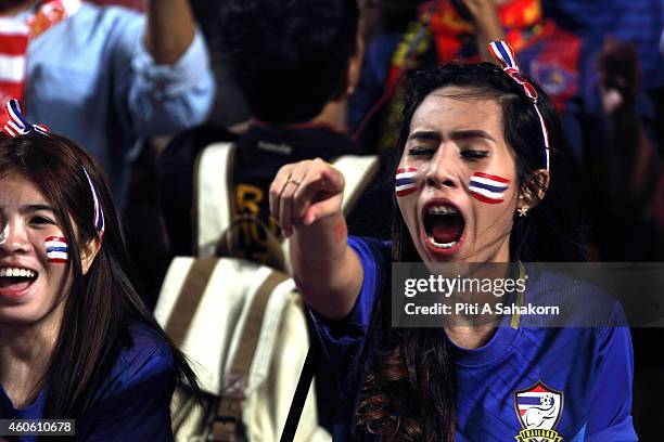 Thai football fans cheer during the first leg match of the 2014 AFF Suzuki Cup final at Rajamangala National Stadium in Bangkok. Thailand defeats...