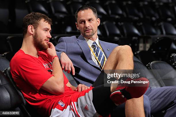 Donatas Motiejunas of the Houston Rockets talks Denver Nuggets Assistant General Manager Arturas Karnisovas prior to their game at Pepsi Center on...