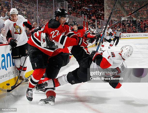 Eric Gelinas of the New Jersey Devils checks Kyle Turris of the Ottawa Senators during the third period at the Prudential Center on December 17, 2014...