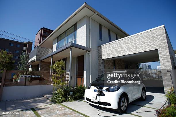 Toyota Motor Corp. EQ compact electric vehicle sits charging while parked outside a model smart home in Toyota's Ecoful Town in the Higashiyama...