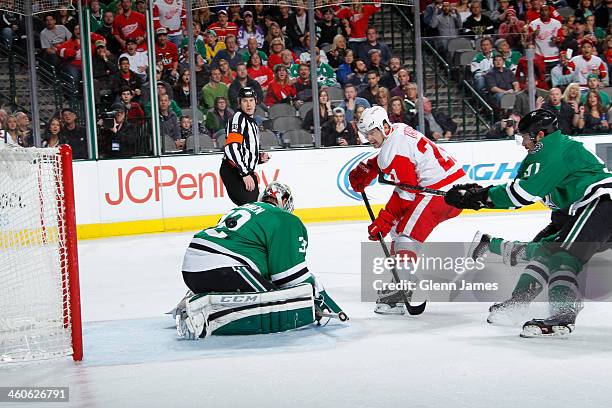 Tomas Tatar of the Detroit Red Wings flips a puck into the net against Kari Lehtonen of the Dallas Stars at the American Airlines Center on January...