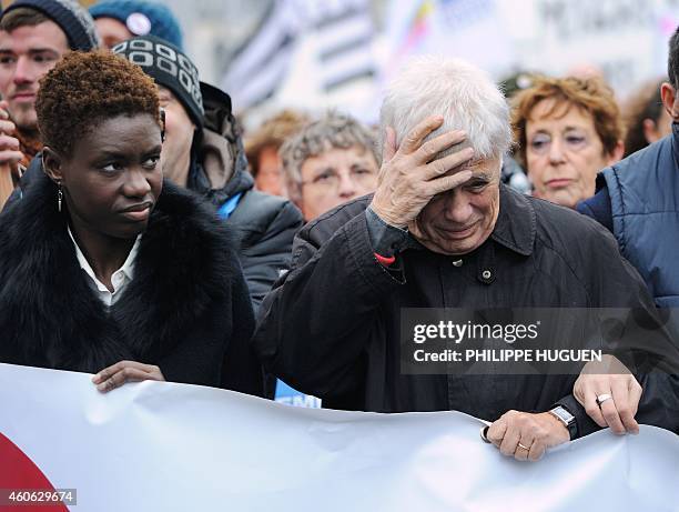 French humorist Guy Bedos and French writer, journalist and activist Rokhaya Diallo march during a protest called on International Migrants Day by...