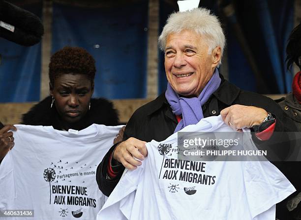 French writer, journalist and activist Rokhaya Diallo and French humorist Guy Bedos hold jerseys reading "Welcome to the Migrants" during a protest...
