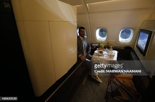 Journalist sits in one of the first class apartments on the Etihad Airways Boeing B787, at Abu Dhabi airport on December 18, 2014 after the Abu...