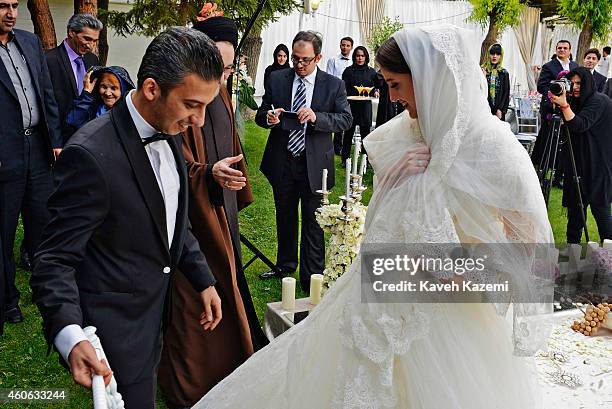 Parmis Taheri and Mostafa Aghaei after their wedding sermons at the social club of Mining & Industry Bank on May 1, 2014 in Tehran, Iran. Parmis is...