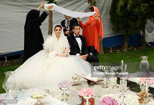 Parmis Taheri and Mostafa Aghaei during their wedding ceremony at the social club of Mining & Industry Bank on May 1, 2014 in Tehran, Iran. Parmis is...