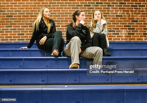 Windham varsity basketball players Julia Linevitch, left, Sadie Nelson, center, and Mya Mannette watch the game against Sanford at USM in Gorham, ME...