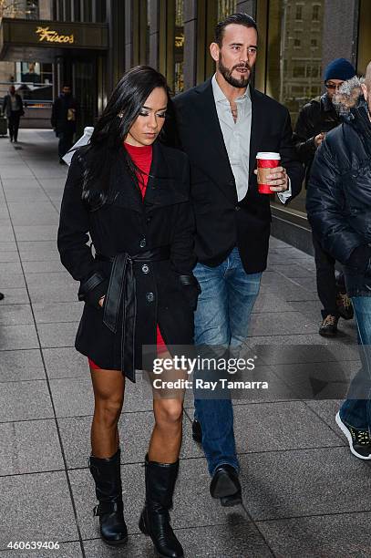 Wrestlers AJ Lee and CM Punk enter the Sirius XM Studios on December 18, 2014 in New York City.