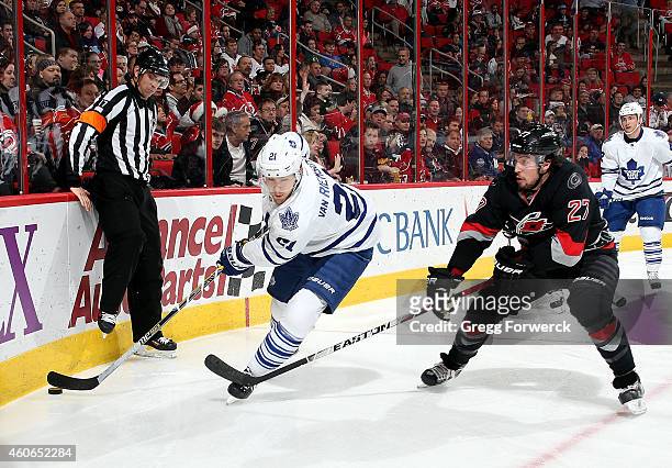 Justin Faulk of the Carolina Hurricanes stick checks James van Riemsdyk of the Toronto Maple Leafs as he moves the puck around the boards during...