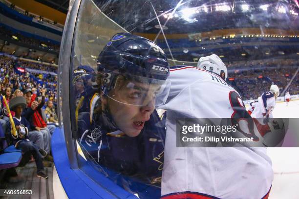 Magnus Paajarvi of the St. Louis Blues is pinned against the boards by Nathan Horton of the Columbus Blue Jackets at the Scottrade Center on January...