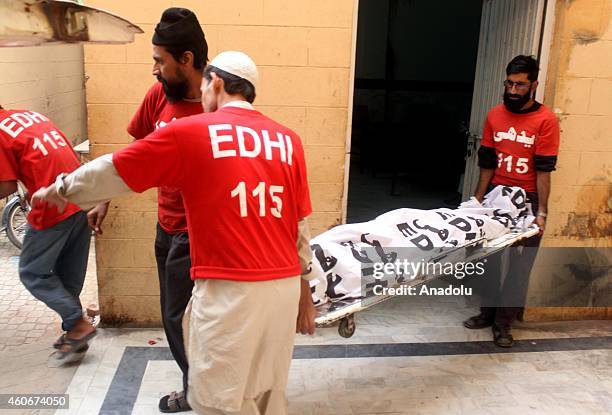 Pakistani emergency workers from a largest private charity organization Edhi carry the body of a Tehrik-i-Taliban Pakistan militant at the hospital...