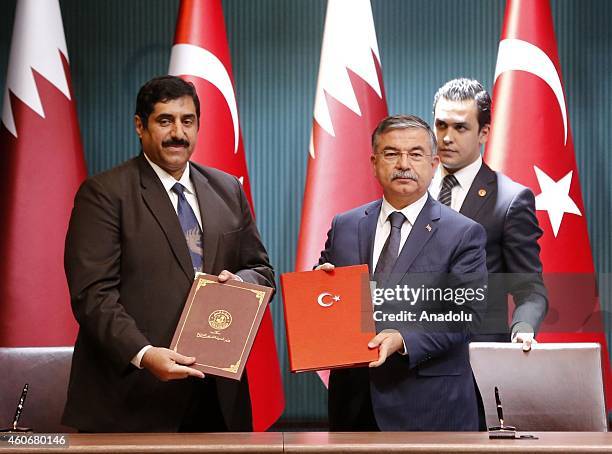 Qatar's Defence Minister Major General Hamad bin Ali Al-Attiyah and Turkey's Defence Minister Ismet Yilmaz pose during the ceremony of the signature...