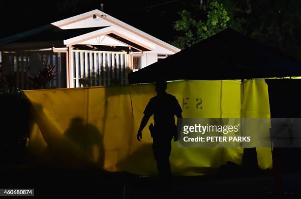 Police officer works at the scene where eight children ranging from babies to teenagers were found dead in a house in the northern Australian city of...