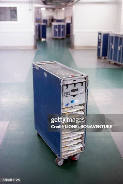 This photo taken on December 8, 2014 shows an airplane food trolley loaded with meal trays at airline catering company Servair's factory at Paris'...