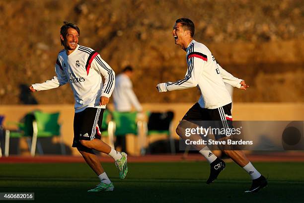 Cristiano Ronaldo of Real Madrid enjoys a joke with Fabio Coentrao during a training session at Le Grande Stade de Marrakech on December 19, 2014 in...