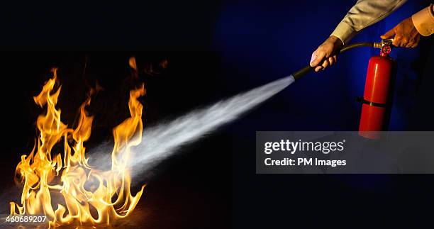 putting out a fire - fire extinguisher stock pictures, royalty-free photos & images