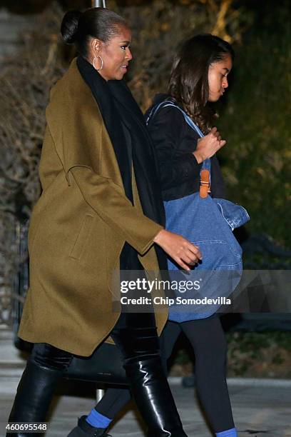 First lady Michelle Obama and her daughter Malia Obama leave the White House for their holiday vacation December 19, 2014 in Washington, DC. The...