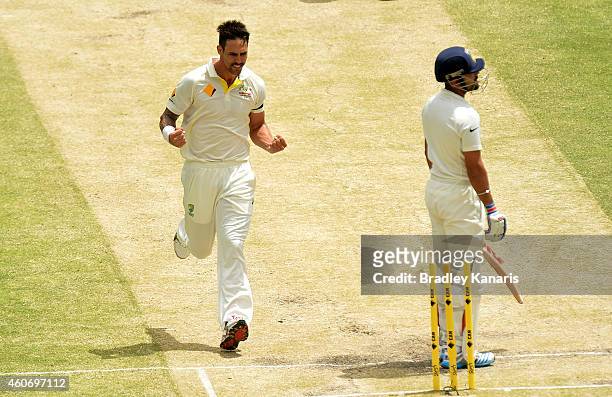 Mitchell Johnson of Australia takes the wicket of Virat Kohli of India during day four of the 2nd Test match between Australia and India at The Gabba...