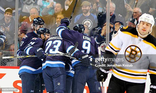 Milan Lucic of the Boston Bruins skates away as Adam Lowry, Grant Clitsome, Jay Harrison and Evander Kane of the Winnipeg Jets celebrate a first...