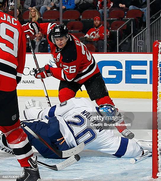 Evgeni Nabokov of the Tampa Bay Lightning make sthe save on Patrik Elias of the New Jersey Devils at the Prudential Center on December 19, 2014 in...