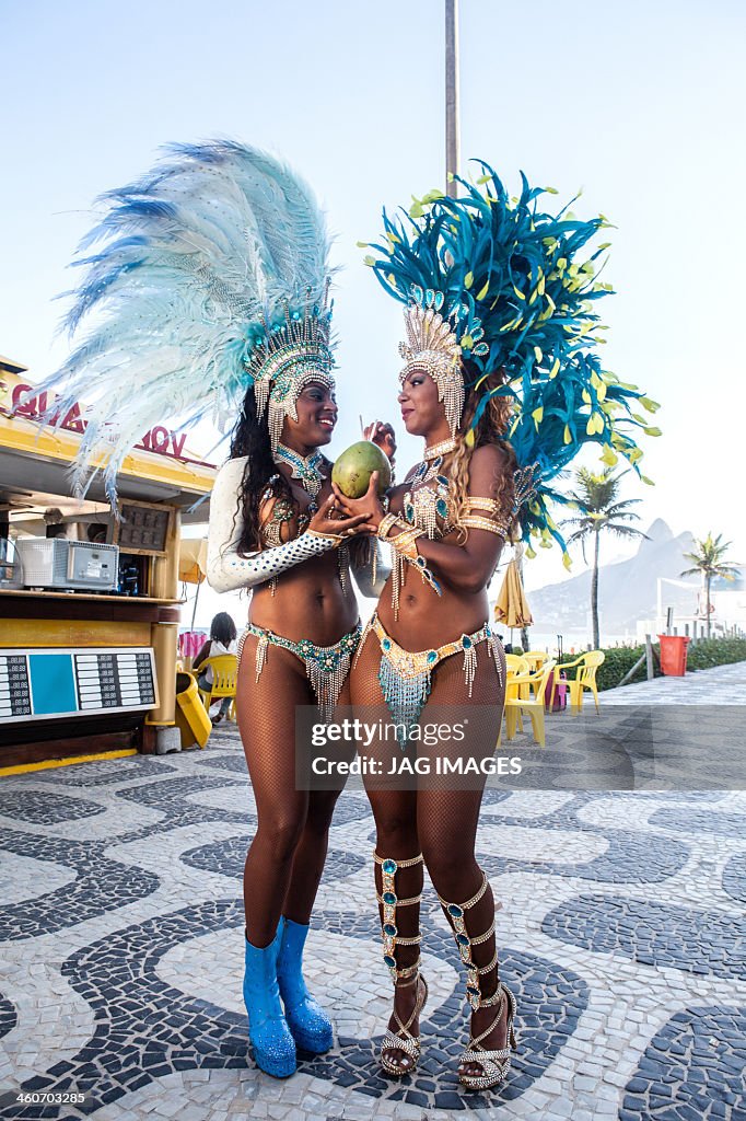 Samba dancers drinking coconut drink, Ipanema Beach, Rio De Janeiro, Brazil