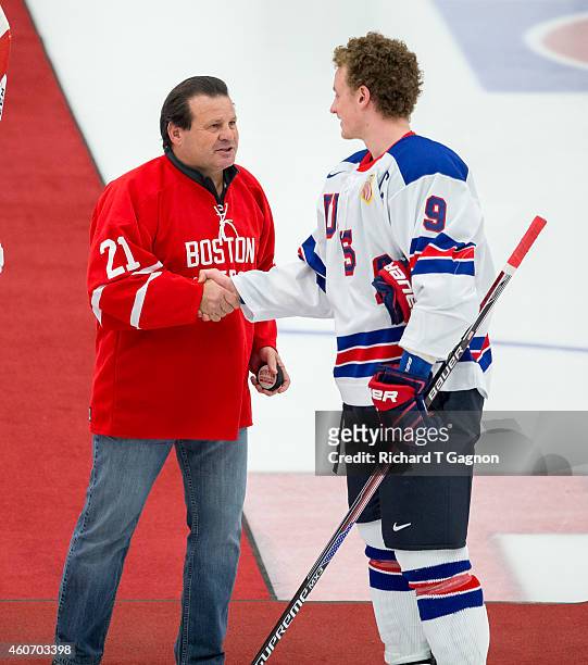 Jack Eichel of the USA National Junior Team shakes hands with former Boston University Terrier and USA olympic hockey player Mike Eruzione before...