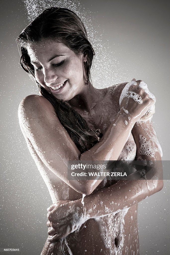 Young woman showering, studio shot