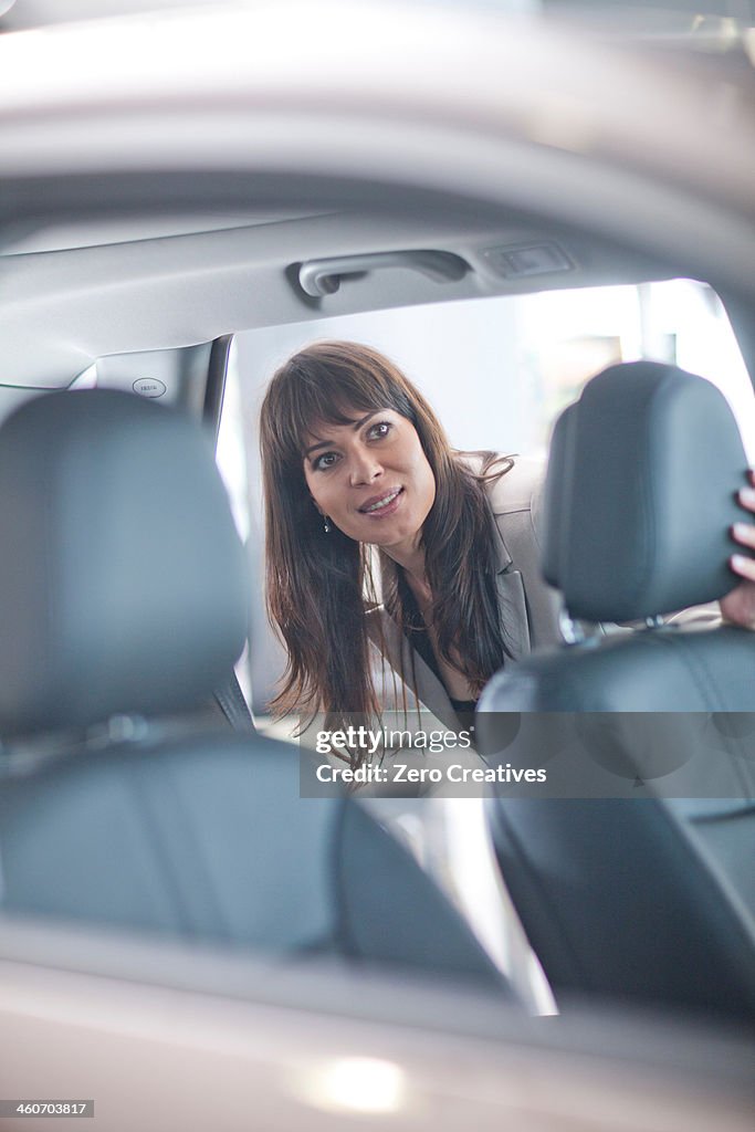 Mid adult woman checking car seat in showroom