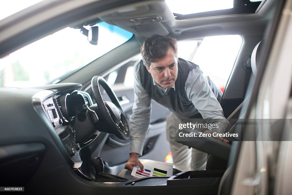 Mid adult man checking arm rest in car showroom