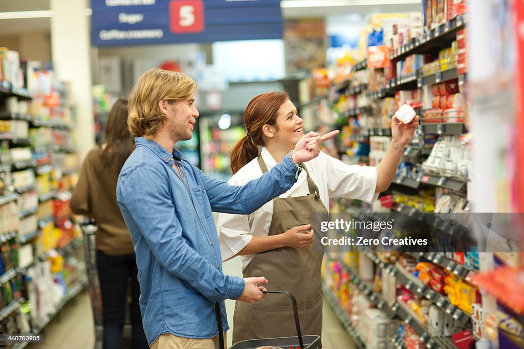 Female shop assistant guiding male customer