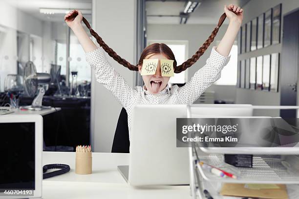 girl in office with adhesive notes covering eyes holding plaits - rolwisseling stockfoto's en -beelden