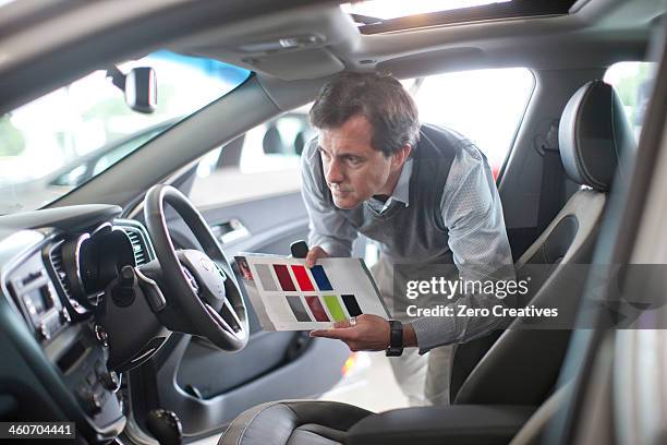 mid adult man with color swatch in car showroom - dashboard fotografías e imágenes de stock