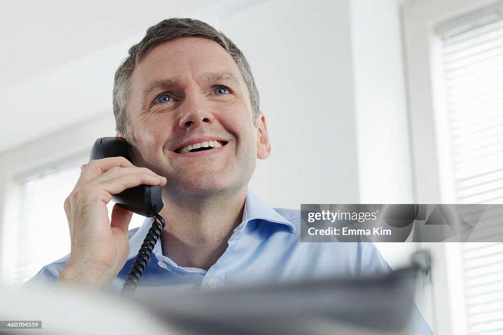 Mature businessman on landline phone