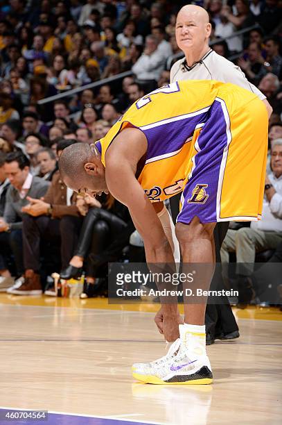 Kobe Bryant of the Los Angeles Lakers ties his shoes during a game against the Oklahoma City Thunder on December 19, 2014 at STAPLES Center in Los...