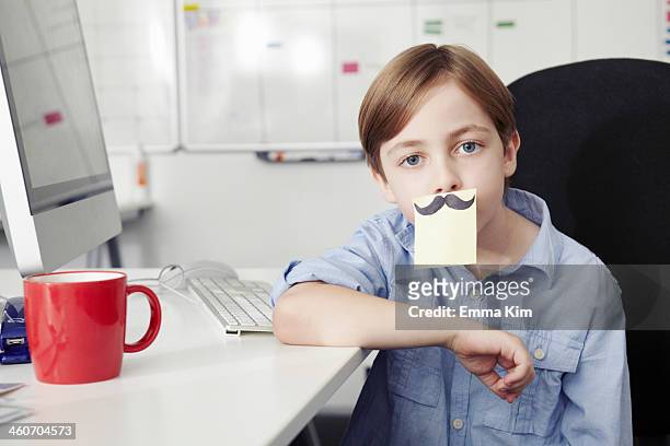 boy with adhesive note covering mouth, drawing of moustache - role reversal stock pictures, royalty-free photos & images