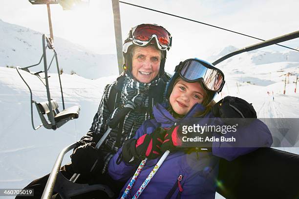 Portrait of grandmother and granddaughter on ski lift, Les Arcs, Haute-Savoie, France