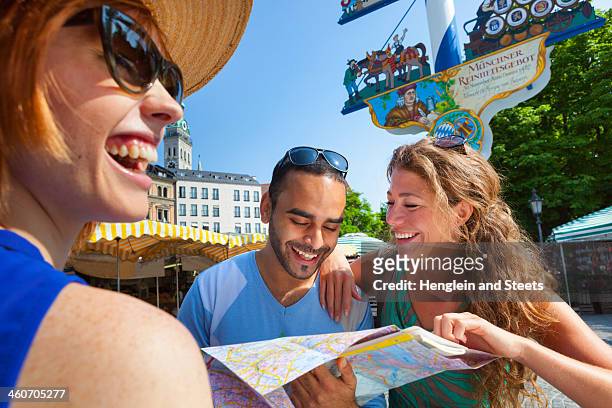 friends looking at map in munich viktualienmarkt, munich, germany - viktualienmarkt stock pictures, royalty-free photos & images