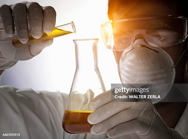 close up of scientist pouring liquid into flask - cu bio science lab fotografías e imágenes de stock