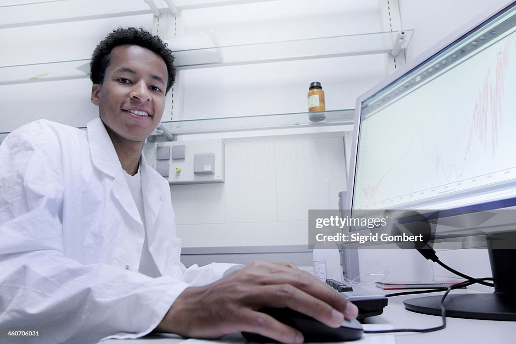 Scientist wearing lab coat working on computer