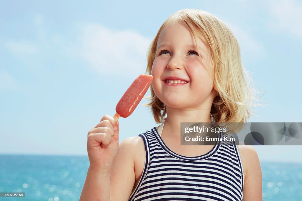 Child with ice lolly looking up