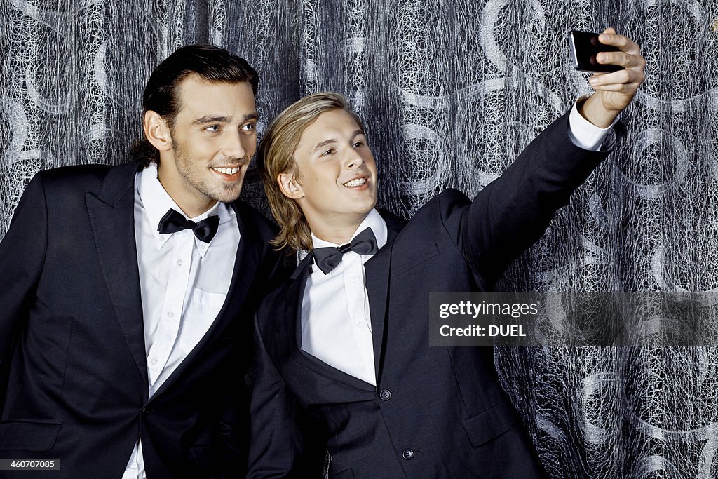 Two young men making self portrait on mobile phone