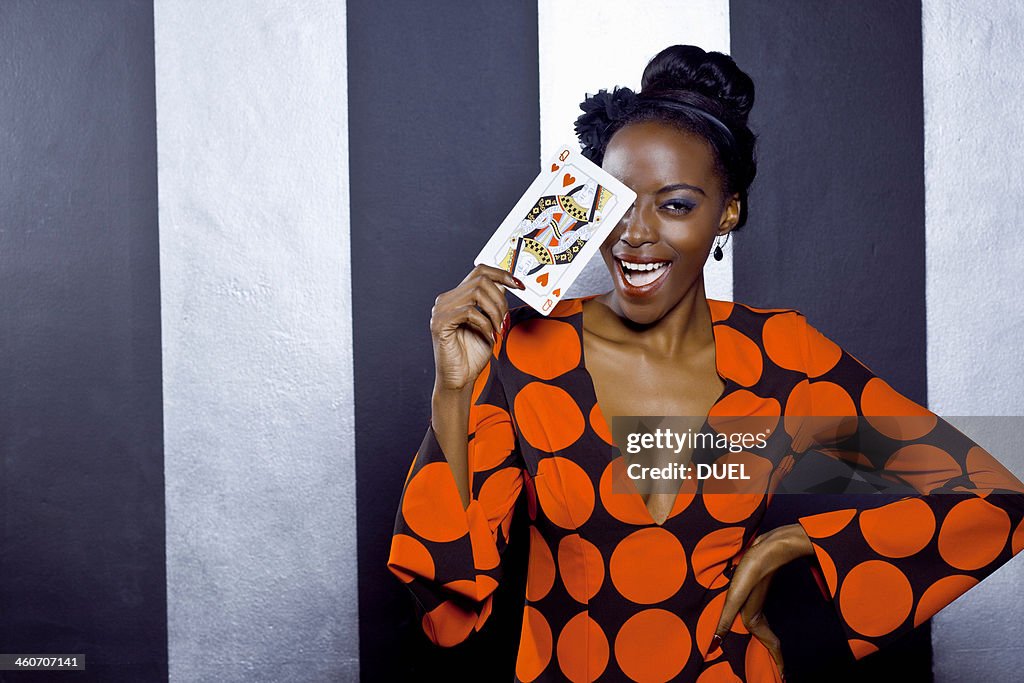 Young woman posing with playing card