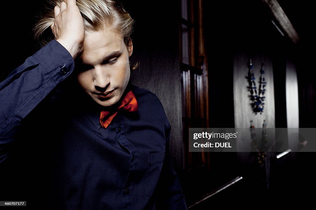 Young man alone in nightclub looking distressed